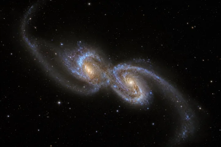 Due galassie in collisione con code mareali luminose, immagine reale telescopio spaziale