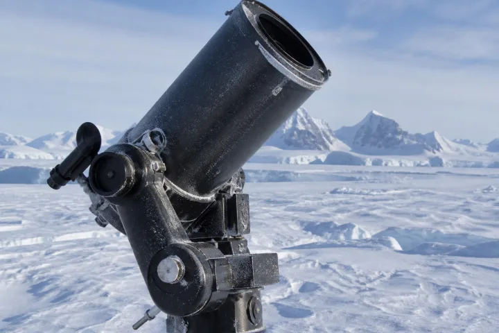 Un osservatorio astronomico nel paesaggio ghiacciato dell'Antartide sotto un cielo notturno stellato